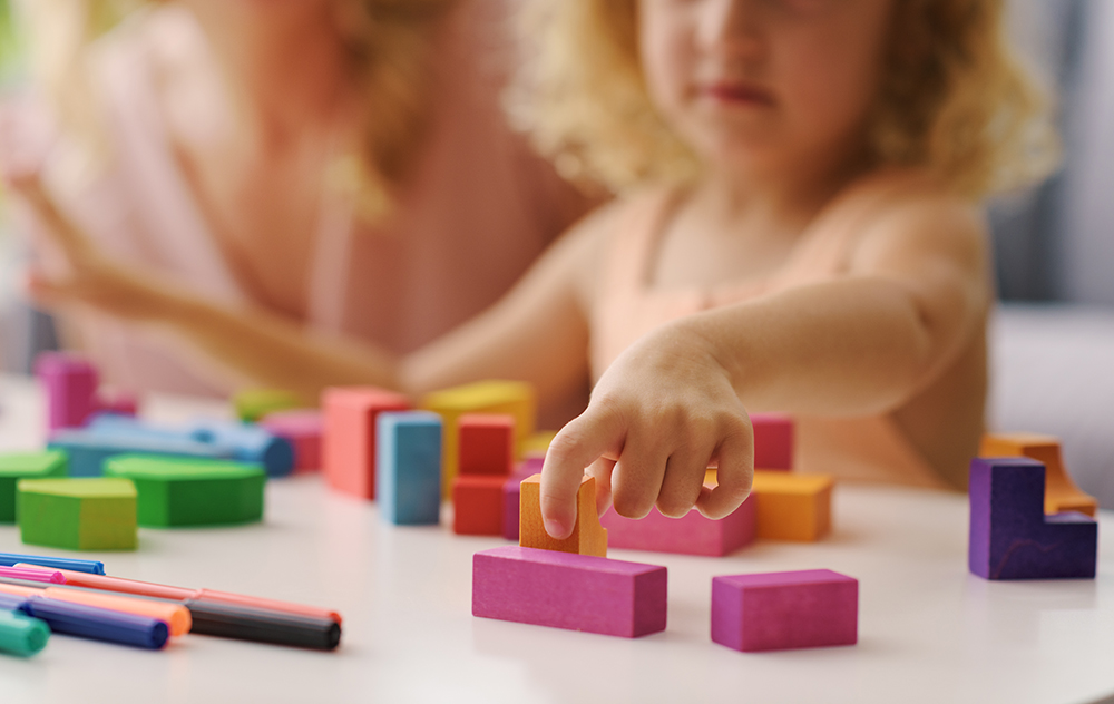 Close up of child playing with colorful wooden blocks