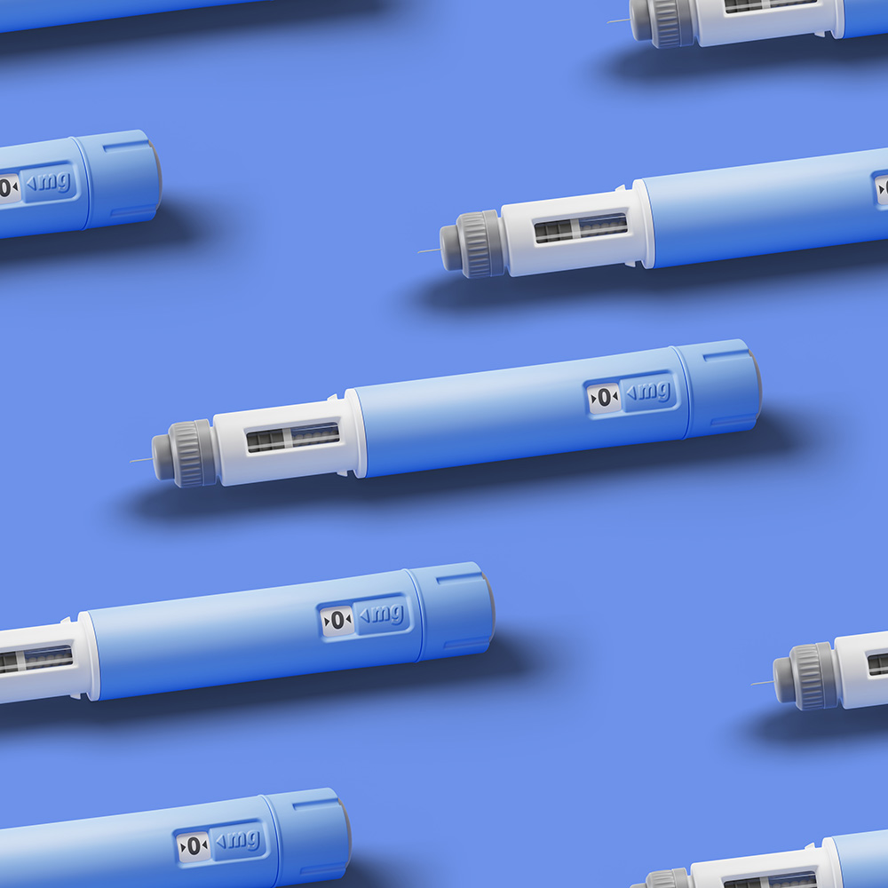 Injection pens for subcutaneous injection of anti-obesity medication on blue background.