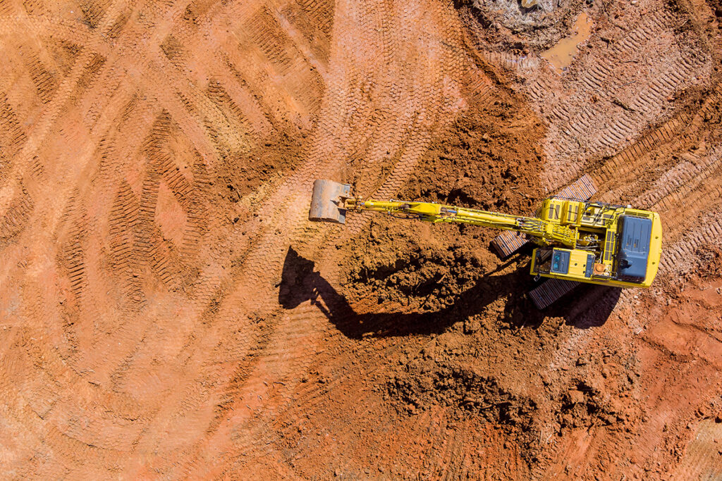 Aerial photo of a bulldozer digging in the dirt on a contstruction site.
