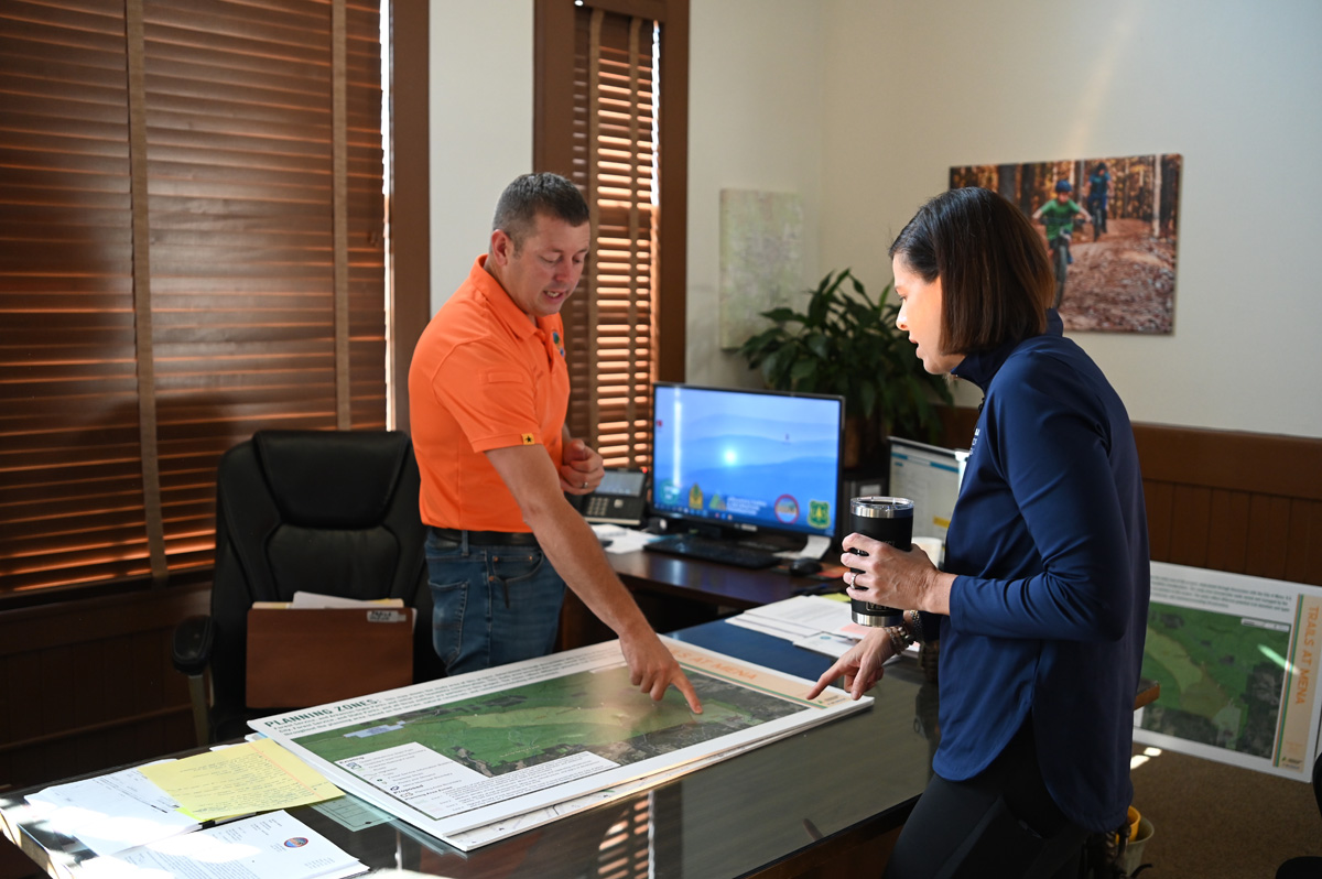 Mena Mayor Seth Smith and Municipal Health Director Katie Bodenhamer look at construction plans for the city's bike trails.