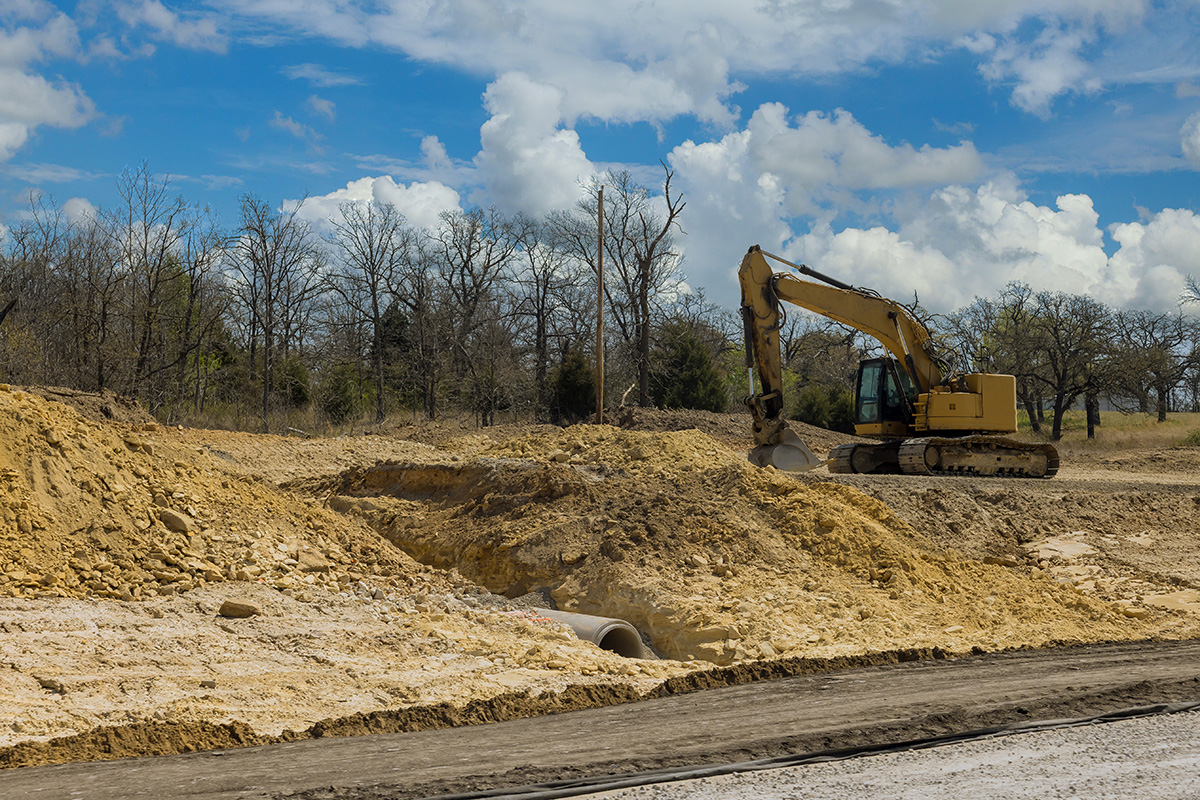 Construction site with bulldozer moving dirt for new road.